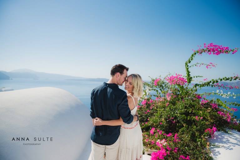 Australian couple hugging in Greece, next to Santorini flowers