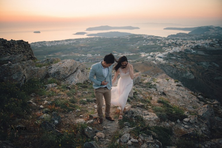Married couple walk on the mountain at sunset