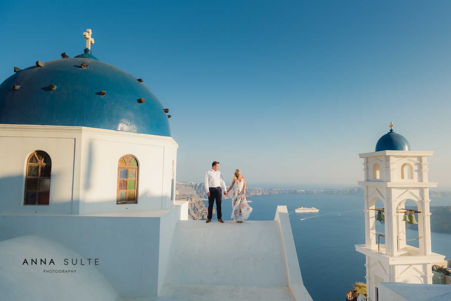Couple holding hands. Church with blue dome.