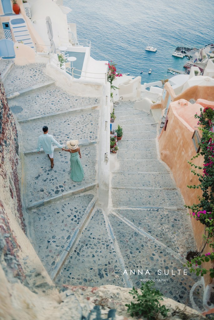Couple waling up the steps from Amoudi Bay to Oia village. Santorini, Greece.