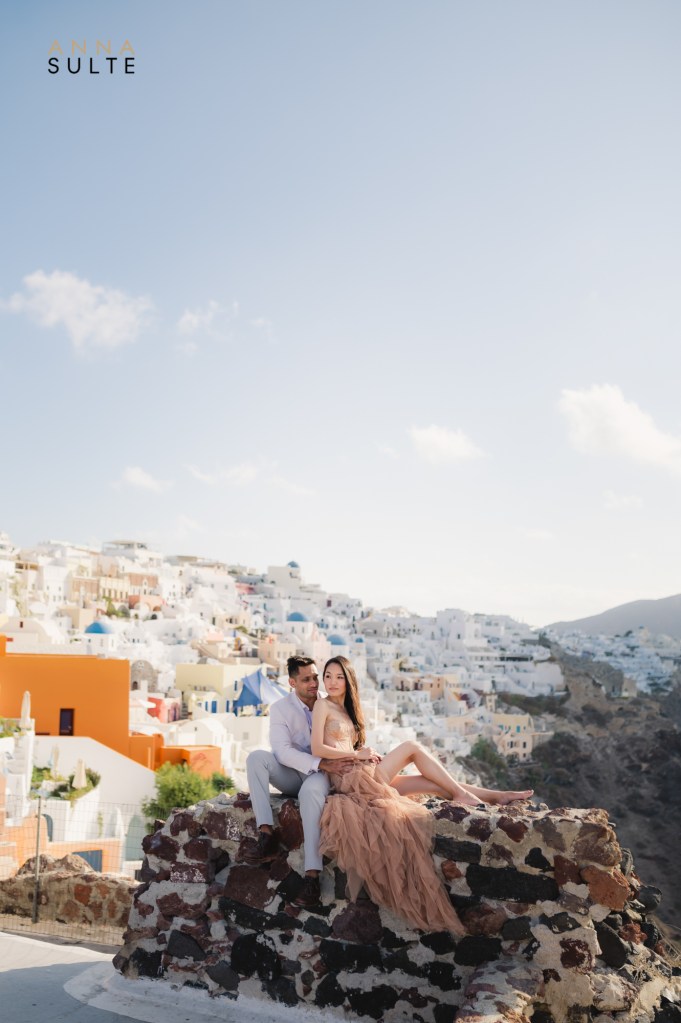 View with a couple and Oia white washed houses and blue domes.