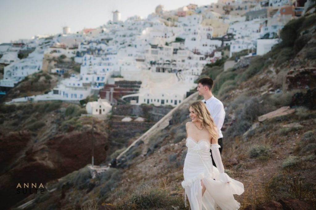 Romantic couple capturing intimate moments in the picturesque village of Oia, Santorini.