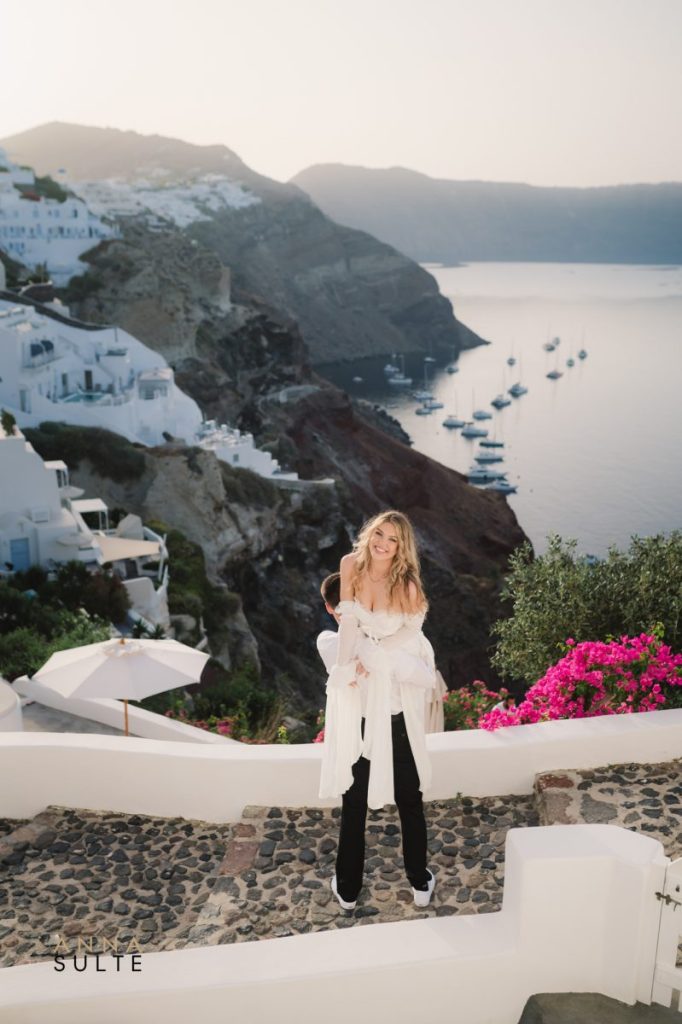Candid shot of a couple laughing together with the Aegean Sea in the background.