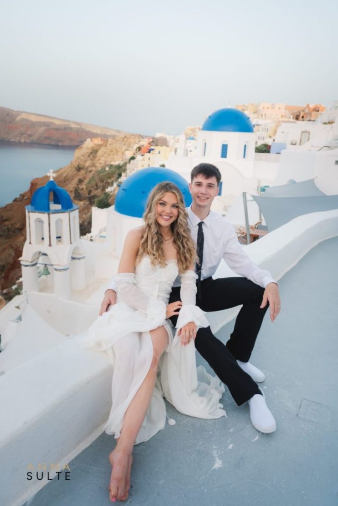 Romantic elopement photoshoot in front of Santorini’s famous blue-domed churches in Oia.