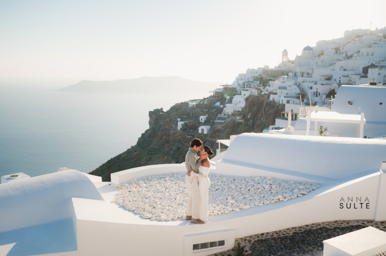 Santorini photoshoot with a couple standing on a rooftop.