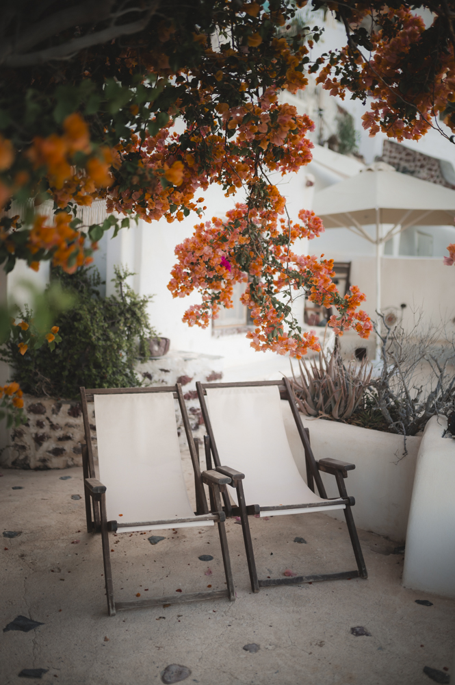 Santorini relax time. Two beach chairs under bougainvillea flowers.