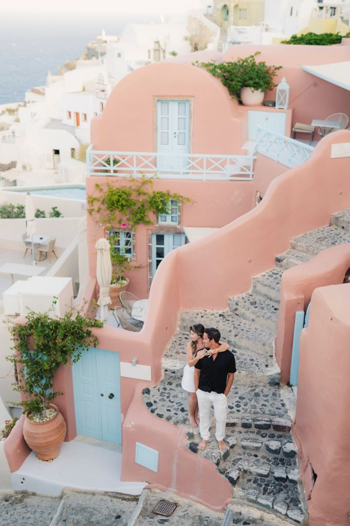 Couples photography in Santorini Greece at sunrise, showcasing terracota house and authentic island atmosphere, captured by a Santorini photographer.