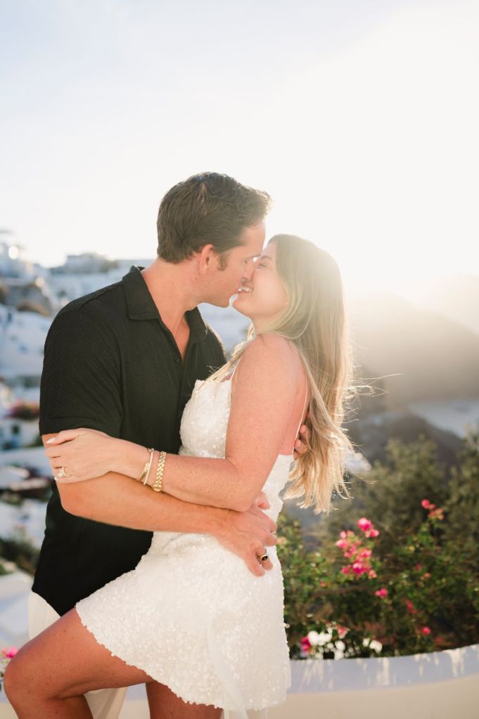 Peaceful sunrise Santorini photoshoot in Oia, featuring a couple against whitewashed caldera views in the background.