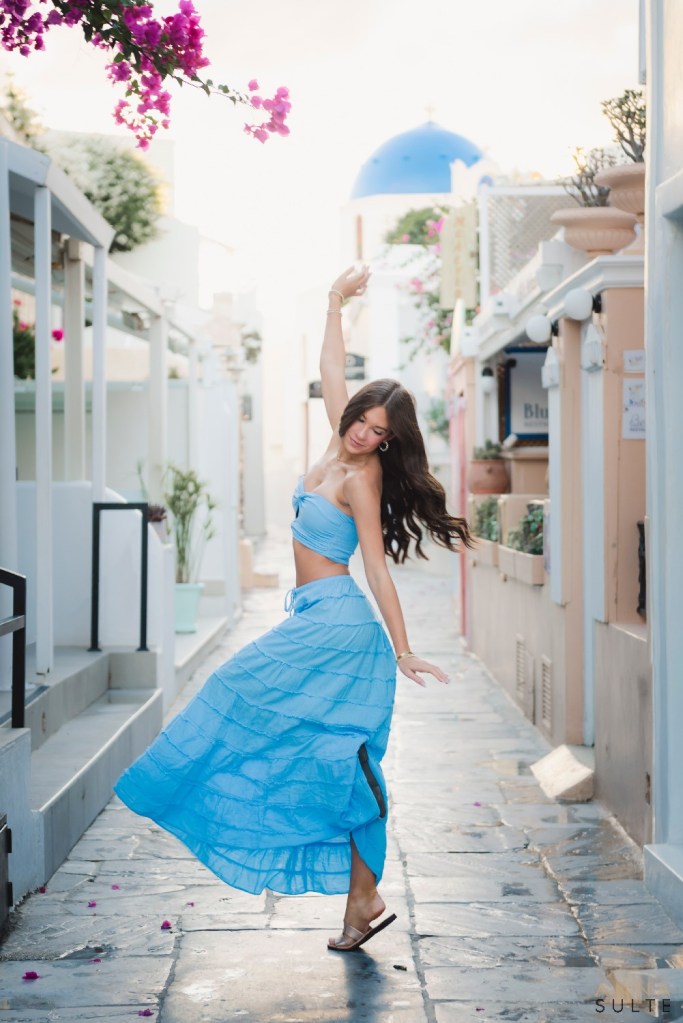 Teen girl spinning playfully on the street in Santorini Greece