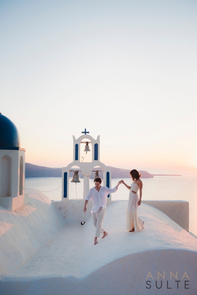 Sunset light over the caldera creates a timeless backdrop for this couple’s photoshoot in Imerovigli, capturing connection and atmosphere.
