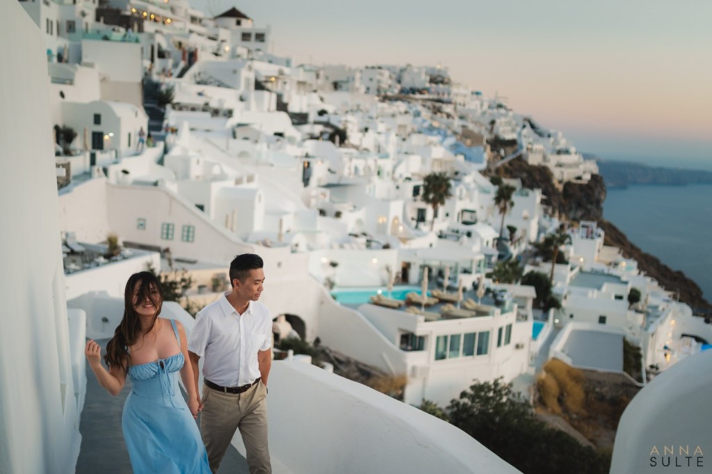 Couple walking along quiet streets in Santorini, ideal for private sunset photoshoots.