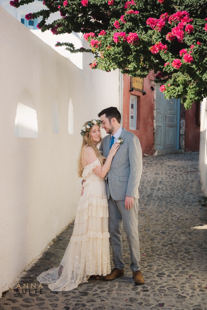 Santorini photographer capturing couple photos in the narrow streets of Oia Greece