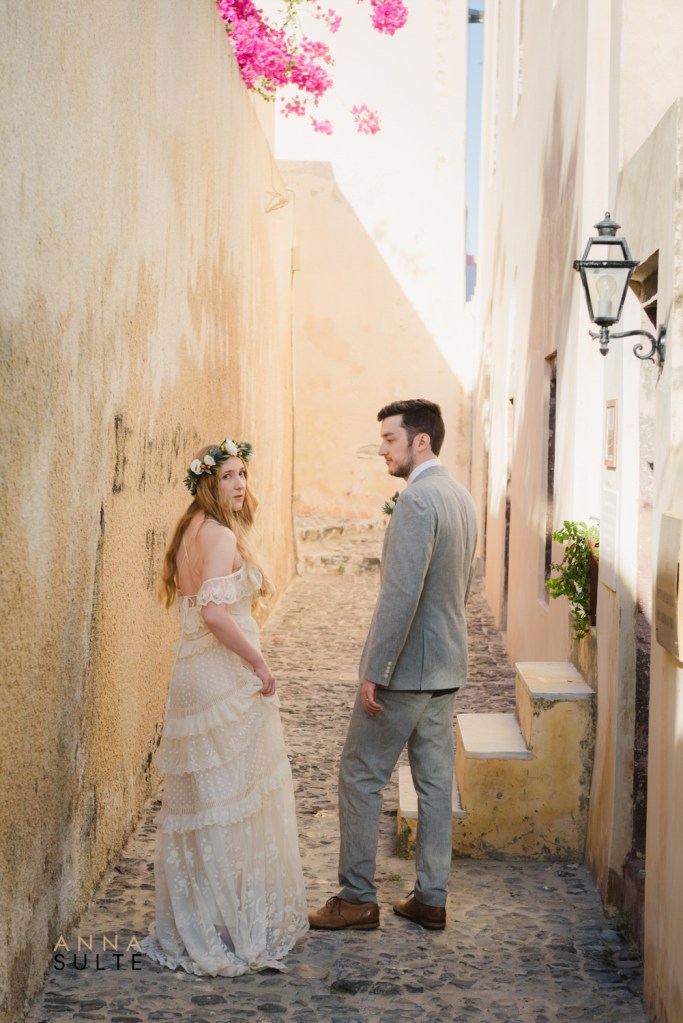 Santorini photographer capturing couple photos in the narrow streets of Oia Greece