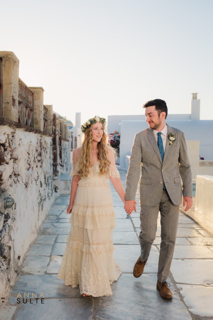 Romantic Santorini couple photoshoot in Oia, walking through white streets