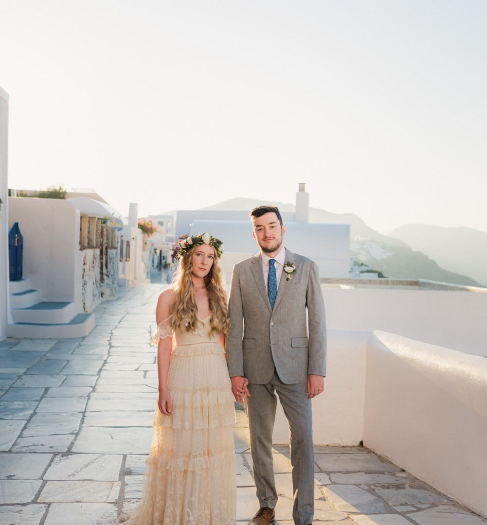 Photographer in Santorini Greece capturing a couple in Oia during golden hour