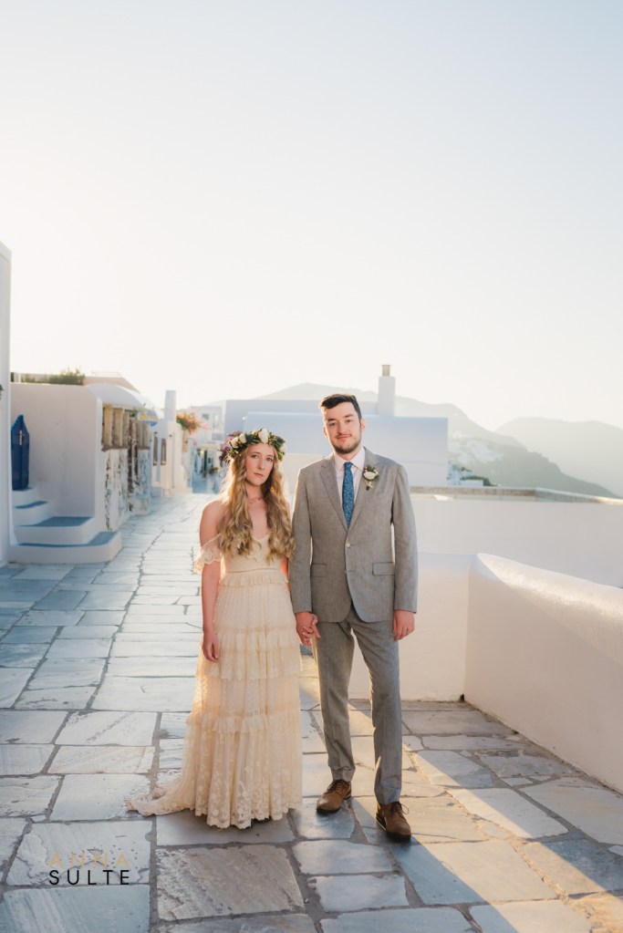 Photographer in Santorini Greece capturing a couple in Oia during golden hour

